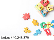 colorful wooden puzzle pieces and wooden puzzle toy, sorter on white background with space. Стоковое фото, фотограф Bogdanova Mariia / Фотобанк Лори