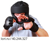 Боевые искусства. Спортсмен в перчатках и шлеме в защитной стойке приготовился нанести правый прямой удар. Стоковое фото, фотограф Олег Безруков / Фотобанк Лори