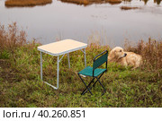 Tourist collapsible chair and table on the background of the autumn landscape. Стоковое фото, фотограф Александр Поташев / Фотобанк Лори