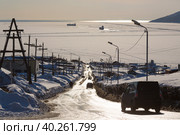 Дорога к морю. Машины едут по улице в сторону морской бухты. Бухта покрыта льдом. Среди льдин корабли. Конец марта на Крайнем Севере. Бухта Нагаева, Магадан, Сибирь, Дальний Восток России. Стоковое фото, фотограф Андрей Степанов / Фотобанк Лори
