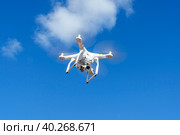 Белоснежный квадрокоптер Dji Phantom оснащенный камерой для съемки фото и видео в солнечном голубом небе. Стоковое фото, фотограф Sergei Gorin / Фотобанк Лори