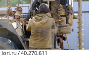 Team of workers with drilling rig on car are drilling artesian well for water in ground. Insertion of metal casing pipe into ground, installation of individual drinking supply, June 28, 2022, Russia, Palaces. Редакционное видео, видеограф Ольга Симонова / Фотобанк Лори
