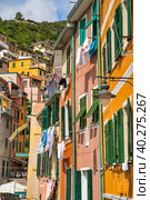 Laundry is dried on the windows of houses. Traditional Italian resort village, Liguria, Italy (2019 год). Стоковое фото, фотограф Илья Курлин / Фотобанк Лори