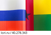Государственные флаги Российской Федерации и Гвинея-Бисау крупным планом. Иллюстрация экономических, политических, культурных отношений (2021 год). Стоковое фото, фотограф Лозовая Людмила / Фотобанк Лори