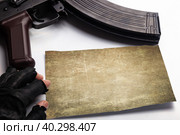 Rifle, gloved hand with human fingers lying on a blank piece of paper on a white background. Стоковое фото, фотограф Владимир Арсентьев / Фотобанк Лори
