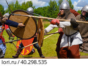 Pskov, Russia, July 10. 2022. Epic Invading Army of Medieval Knights on Battlefield, Plate Body Armored Soldiers with Swords in Battle Cry. Historical Reenactment. Редакционное фото, фотограф Ирина Старикова / Фотобанк Лори