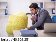 Young male employee looking after newborn at workplace. Стоковое фото, фотограф Elnur / Фотобанк Лори