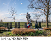 Город Можайск, Московская область. Никольская гора. Братская могила советских воинов, погибших в боях за Можайск во время  Великой Отечественной войны. Мужчина стоит перед мемориалом (2022 год). Редакционное фото, фотограф Наталья Николаева / Фотобанк Лори