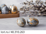 Stylish grey Easter eggs made of marble and concrete with a golden potala on a grey background. Coloring eggs with natural dye karkade tea. Environmental friendliness. Naturalness. The concept of a happy Easter. Стоковое фото, фотограф Photojuli / Фотобанк Лори