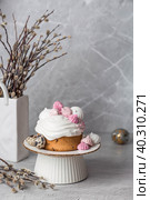 Beautiful stylish still life. Easter cake with meringue, marshmallows, Easter eggs and willow twigs on a light concrete background. happy Easter. Стоковое фото, фотограф Photojuli / Фотобанк Лори