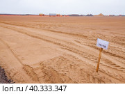 Flat sand subgrade, sign and truck trails. Blue sky on horizon. Стоковое фото, фотограф Alexey Rezvykh / Фотобанк Лори