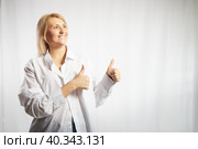 Portrait of a pretty blonde smiling woman posing on a white background. Happy girl model in white shirt in studio. Lady winner is joyfull. Copy space. Стоковое фото, фотограф Кривошеина Елена Леонидовна / Фотобанк Лори