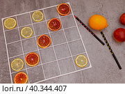 Игры с детьми на кухне. Красные победили. Игра в "крестики-нолики" лимоном и красным апельсином. Стоковое фото, фотограф Татьяна Бакуменко / Фотобанк Лори