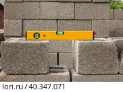 The bubble construction level lies on a cinder block construction stone. It is used by carpenters, masons, installers for various mounting and fastening works. Стоковое фото, фотограф Неведицына Елена / Фотобанк Лори