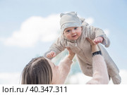 Cute little boy playing with his mom outside. A happy child is tossed up in the park. The kid laughs merrily. Portrait of a boy. Mothers Day. Стоковое фото, фотограф Photojuli / Фотобанк Лори