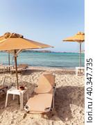 Greece. Crete. Bay of Balos or Lagoon of the Three Seas. View of a cozy sandy beach with umbrellas and sun loungers. The concept of summer holidays at sea (2014 год). Стоковое фото, фотограф Виктория Катьянова / Фотобанк Лори
