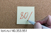 Девушка пишет надпись 80% красным маркером на желтом бумажном стикере, приклеенном к пробковой доске. Женская рука с цветным фломастером. Рукописный текст красивым почерком. Процент скидки, убытка или прибыли. Girl writes the inscription 80% with red marker on yellow paper sticker glued to cork board. Woman hand with colored felt-tip pen. Handwritten text in beautiful handwriting. Percentage of discount, loss or profit. Стоковое видео, видеограф Ирина / Фотобанк Лори