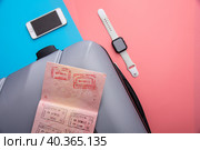 A flat with a gray tourist suitcase, a smartphone, and glasses on a pink-blue background. Стоковое фото, фотограф Ярославский Максим / Фотобанк Лори