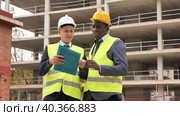 Two successful architects standing on the construction site are discussing the construction plan, holding drawings in their hands. Стоковое видео, видеограф Яков Филимонов / Фотобанк Лори