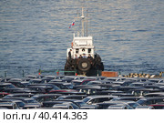 Буксир с пограничниками и разгруженные с морского судна автомобили в торговом порту Владивостока (2022 год). Редакционное фото, фотограф Free Wind / Фотобанк Лори