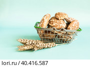 Продуктовая корзина, полная свежих пряников и пшеничные колоски крупным планом на светлом фоне. Стоковое фото, фотограф Лозовая Людмила / Фотобанк Лори