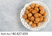 Amaretti-traditional Italian almond cookies in a white plate on a gray concrete background top view. Amarettini biscuits. Selective focus, copy space. Стоковое фото, фотограф Виктория Панченко / Фотобанк Лори