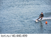 Motosurf Competitor taking corner at speed making a lot of spray. Jet surfing on a water, man riding on jet surfboard. Surfer in motion, summer sport. Стоковое фото, фотограф Олег Спиридонов / Фотобанк Лори