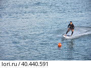 Motosurf Competitor taking corner at speed making a lot of spray. Jet surfing on a water, man riding on jet surfboard. Surfer in motion, summer sport. Стоковое фото, фотограф Олег Спиридонов / Фотобанк Лори