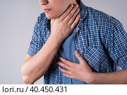 Sore throat, men with pain in neck on gray background. Стоковое фото, фотограф Станислав Тарко / Фотобанк Лори