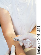 A girl doctor injects a syringe on her arm into a vein of an adult woman. Стоковое фото, фотограф Юрий Поздников / Фотобанк Лори