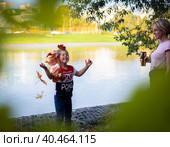 The girl throws colorful maple leaves for a walk in the park. Russia Moscow September 24, 2020. Редакционное фото, фотограф Юрий Поздников / Фотобанк Лори