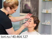 Master stylist makes eye makeup for a girl in a beauty salon. Russia Moscow August 20, 2020. Редакционное фото, фотограф Юрий Поздников / Фотобанк Лори