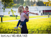 Mom plays and dances with children in the park, laughs and spins with happiness. Russia Moscow September 24, 2020. Редакционное фото, фотограф Юрий Поздников / Фотобанк Лори