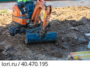 A minitractor rakes the earth with a bucket. Land works. Стоковое фото, фотограф Юрий Поздников / Фотобанк Лори