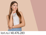 Thinking woman standing pensive contemplating looking skeptic. Стоковое фото, фотограф Сергей Толмачёв / Фотобанк Лори