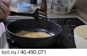 A man flips a pancake with a spatula in a pan. Стоковое видео, видеограф Юрий Поздников / Фотобанк Лори