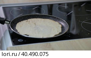 A man tosses a pancake on a frying pan. Стоковое видео, видеограф Юрий Поздников / Фотобанк Лори