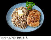 buckwheat with meat cutlets on a black background side view. Стоковое фото, фотограф Татьяна Терехина / Фотобанк Лори