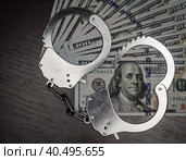 One hundred dollar bills and steel handcuffs close up. Стоковое фото, фотограф Артем Курутин / Фотобанк Лори