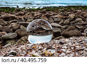 Glass ball lens lies on the sand of the sea shore. Стоковое фото, фотограф Артем Курутин / Фотобанк Лори