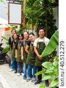 Vietnamese coffee shop team smiling and standing together against a cafe. Стоковое фото, фотограф Татьяна Терехина / Фотобанк Лори