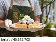 Woman holding Belgium waffles with dragon fruit and ice cream on a plate. Стоковое фото, фотограф Татьяна Терехина / Фотобанк Лори