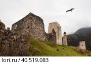 Panoramic view of Erzi watchtower complex. Misty morning in the Caucasus mountains. Medieval tower on foggy mountain slope background. Dzheyrakh gorge, Ingushetia. (2022 год). Стоковое фото, фотограф Саблин Станислав / Фотобанк Лори