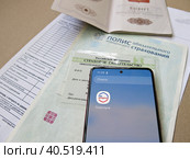 Персональные данные гражданина РФ: паспорт, медицинский полис, СНИЛС и телефон с электронным приложением Государственные слуги (2023 год). Редакционное фото, фотограф Татьяна Т / Фотобанк Лори