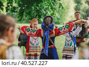 Russian folk traditions. Folk festivals. Children in beautiful Russian traditional outfits sing songs, dance and lead a round dance in Tsaritsyno Park. National Russian clothes. Sundresses and kokoshniks. (2023 год). Редакционное фото, фотограф Photojuli / Фотобанк Лори