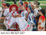 Russian folk traditions. Folk festivals. Children in beautiful Russian traditional outfits hold a loaf and sing songs in Tsaritsyno Park. National Russian clothes. Sundresses and kokoshniks. (2023 год). Редакционное фото, фотограф Photojuli / Фотобанк Лори