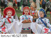Russian folk traditions. Folk festivals. Children in beautiful Russian traditional outfits hold a loaf and sing songs in Tsaritsyno Park. National Russian clothes. Sundresses and kokoshniks. (2023 год). Редакционное фото, фотограф Photojuli / Фотобанк Лори