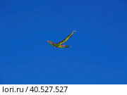 A kite is flying in the bright blue sky. Summer games and leisure. (2023 год). Стоковое фото, фотограф Photojuli / Фотобанк Лори