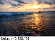 Wave and sunset over sea. Beautiful sunset. Foamy waves roll over the sandy shore. Vityazevo, Anapa, Black Sea. Tourist mecca, health resort. Evening sky. The rays reflect off the water. Стоковое фото, фотограф Юлия Петровская / Фотобанк Лори