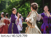 Reconstruction of the court ball of the mid-18th century of Her Imperial Majesty Catherine II in the Tsaritsyno Park in Moscow. Girls in ball gowns dance in the fresh air. (2023 год). Редакционное фото, фотограф Photojuli / Фотобанк Лори